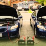 Two Toyota vehicles with open hoods undergoing a car battery jump start process, illustrating how to find the right car battery by vehicle.