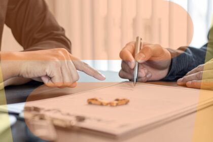 Close-up of a person pointing to a document while another signs a contract, representing a vehicle spec check or buying a car by registration number.