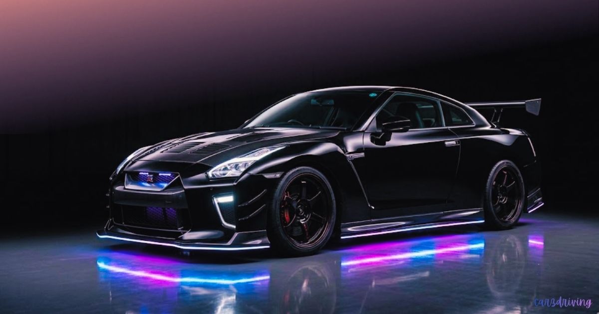 Sleek black Nissan GT-R car with LED underglow lights glowing in vivid blue and pink on a dark reflective studio floor