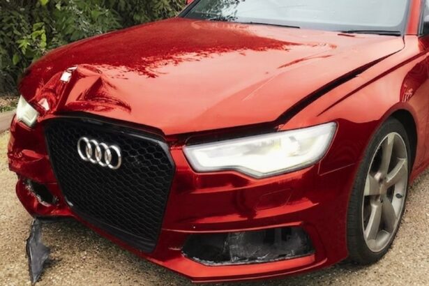 A damaged metallic red Audi station wagon shown from the front-left angle. The front bumper is cracked, and the hood is dented, illustrating a vehicle classified as Category N, signifying non-structural damage that is repairable.