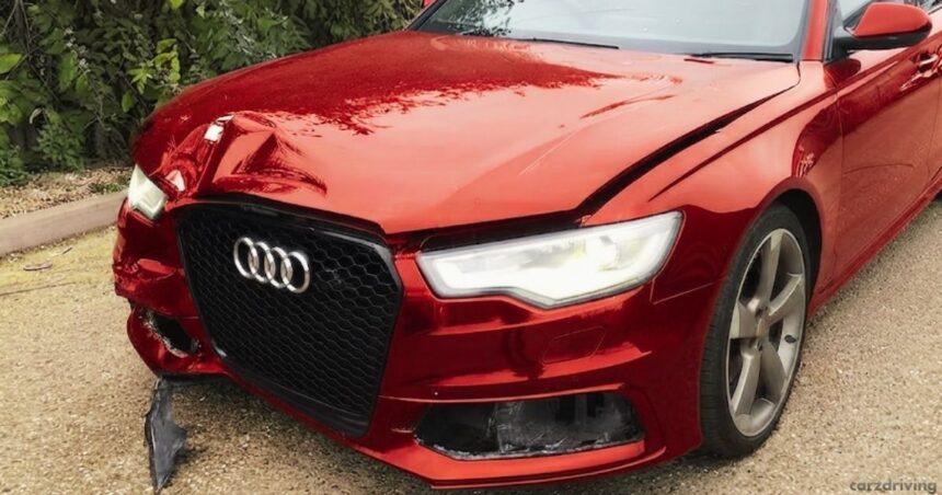 A damaged metallic red Audi station wagon shown from the front-left angle. The front bumper is cracked, and the hood is dented, illustrating a vehicle classified as Category N, signifying non-structural damage that is repairable.