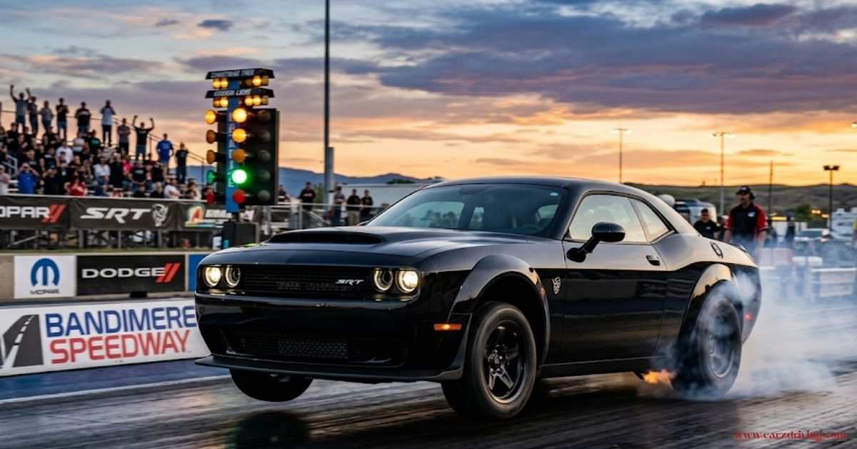 A black demon dodge demon Challenger SRT Demon launching down the drag strip at Bandimere Speedway, with its front wheels lifted off the ground and smoke trailing from the rear tires against a sunset background.