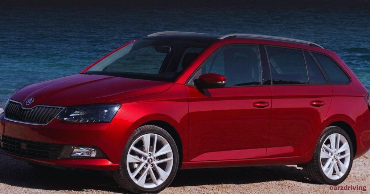 Red Škoda Fabia station wagon with silver alloy wheels and roof rails, parked near the coast.