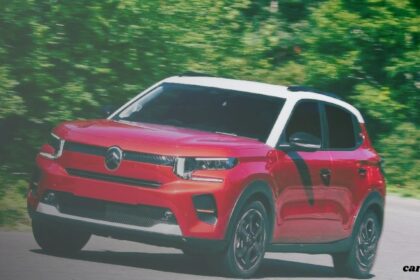 A front three-quarter view of a red Citroën compact SUV with a contrasting white roof and black pillars, captured in motion on a paved road. The background shows blurred green trees, indicating speed, and a "carzdriving" watermark is in the bottom right corner.