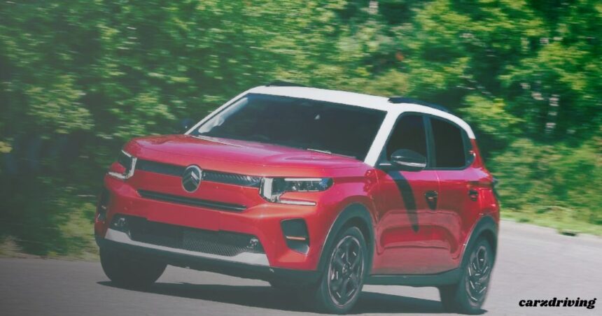 A front three-quarter view of a red Citroën compact SUV with a contrasting white roof and black pillars, captured in motion on a paved road. The background shows blurred green trees, indicating speed, and a "carzdriving" watermark is in the bottom right corner.