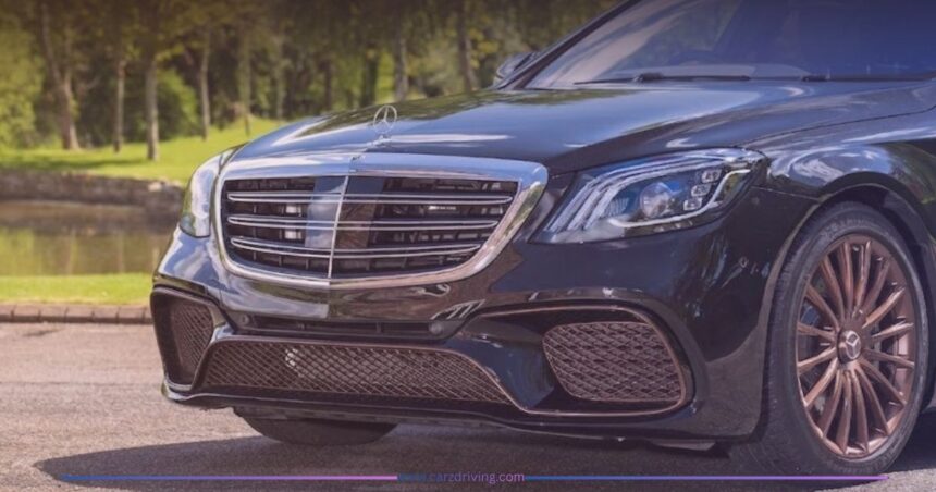 Close-up front view of a black Mercedes-AMG S65 luxury sedan featuring a chrome grille, distinctive LED headlights, and custom bronze multi-spoke alloy wheels parked outdoors.