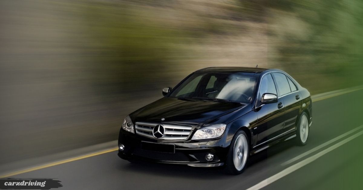 A black Mercedes-Benz C-Class (W204) sedan driving on an open road with a high-speed motion blur effect.