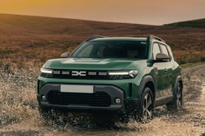 A green Dacia Duster driving off-road and splashing water on a dirt track.