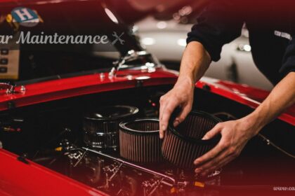 Mechanic replacing engine air filters during routine car maintenance on a classic red car