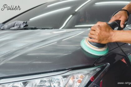 Person using a dual-action buffer machine to apply car polish onto a dark vehicle hood