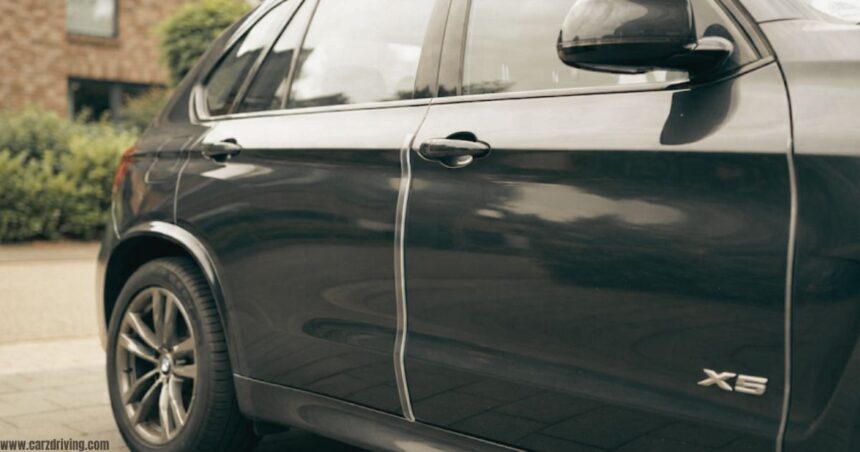 "Clear car door protector strip installed on a BMW X5 to prevent door dings and scratches in parking spaces."