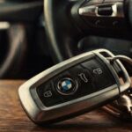 BMW smart key fob resting on a dashboard, illustrating car key replacement near me services.