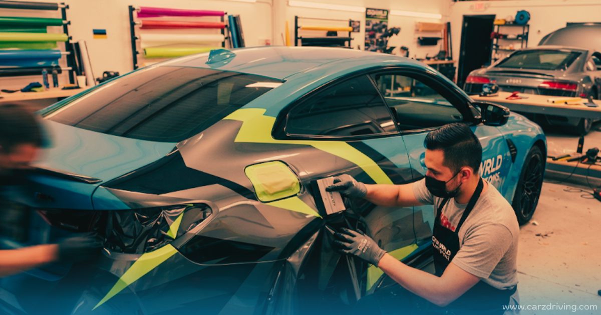 Car technician applying custom geometric vinyl wrap to a sports car at a professional car wrapping near me service shop
