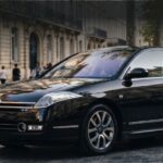 Elegant black Citroën C6 executive car, showcasing its distinctive design parked in a city setting.