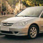 Honda Civic IMA hybrid parked on a town street; front three-quarter view showing the sedan's silver exterior and classic design.