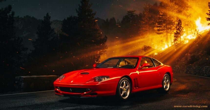 A red Ferrari 550 Maranello parked on a dark road at night, illuminated by the bright, fiery orange glow of a nearby wildfire in the background.