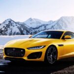 "Bright yellow Jaguar F-Type R coupe parked on a snowy road with mountains in the background."