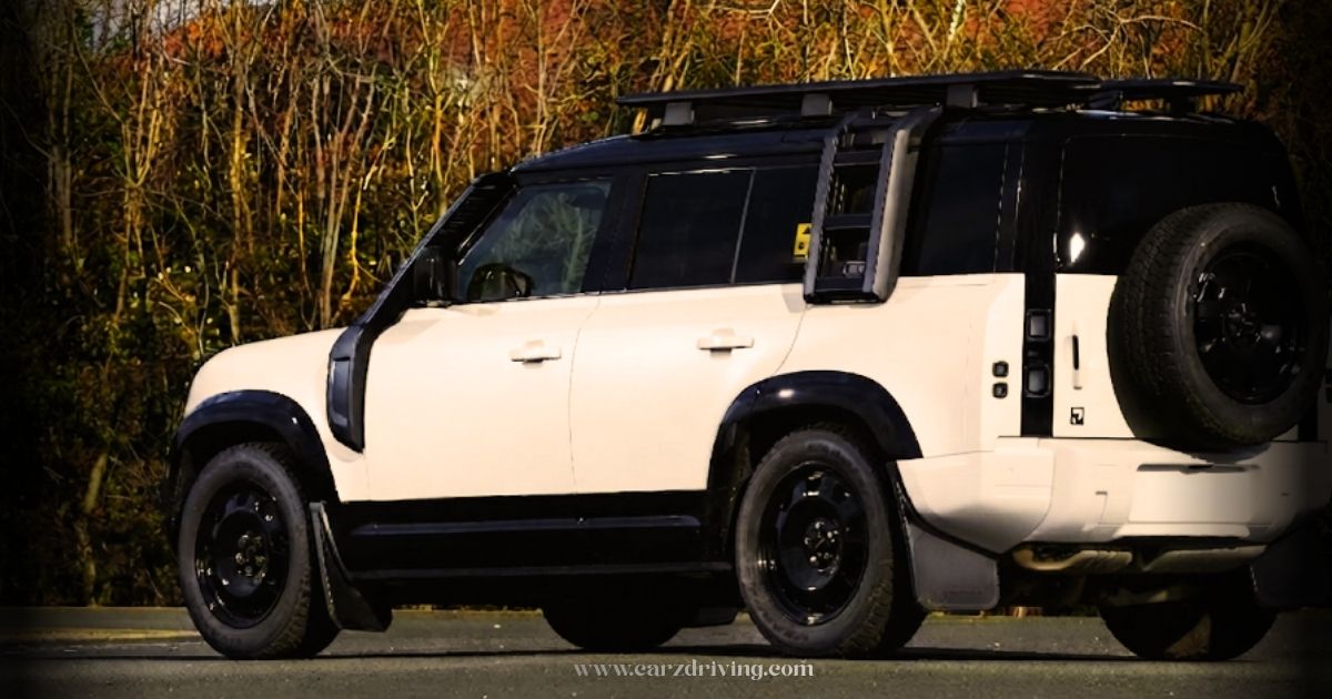 Side profile view of a two-tone off-white and black Land Rover Defender Sport parked outdoors, featuring a roof rack, side-mounted ladder, snorkel, and black steel wheels with a rear-mounted spare tire.