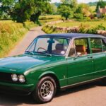 Vintage Triumph Dolomite sedan in green, parked on a countryside lane, perfect for classic car enthusiasts.
