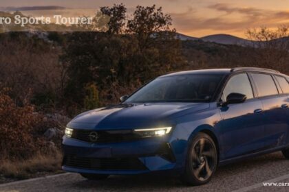 Blue Opel Astra Sports Tourer estate car driving on a scenic road at sunset.
