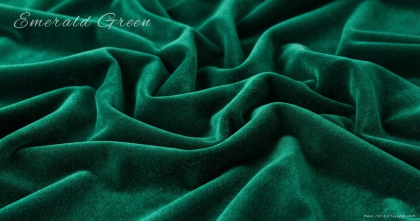 A rich emerald green velvet fabric draped in soft, deep folds with a subtle sheen, featuring the words "Emerald Green" written in elegant script in the upper-left corner.