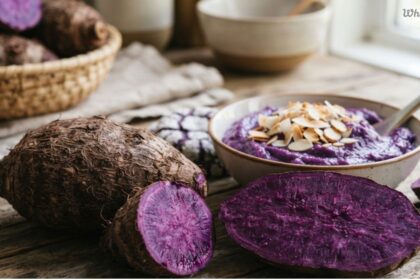 Fresh whole and sliced purple ube yams next to a bowl of ube dessert to explain what is ube