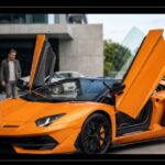Orange Lamborghini sports car featuring open scissor automobile door mechanism.