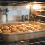 Cooked prawns with garlic and herbs being reheated in a warm oven, demonstrating can you reheat prawns safely for meals.