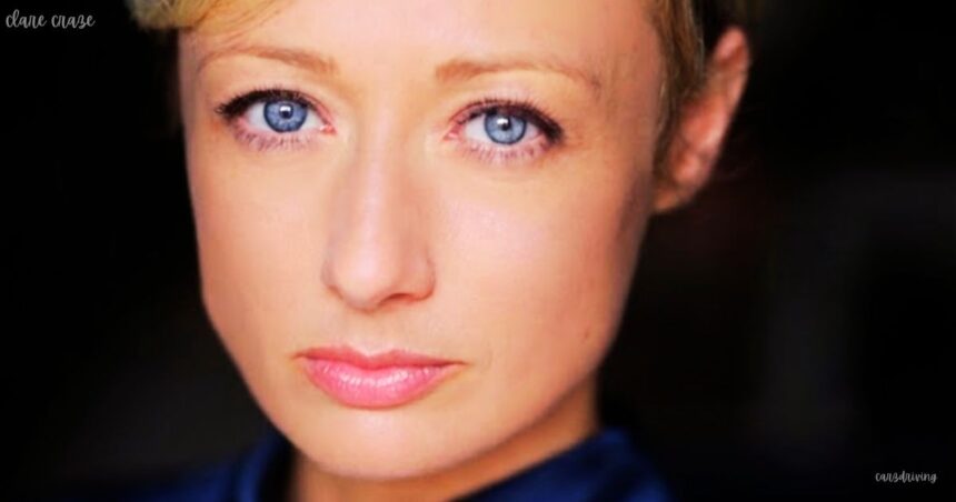 A close-up headshot of clare craze fair-skinned woman with short blonde hair and striking blue eyes, facing forward with a neutral expression and light pink lipstick.