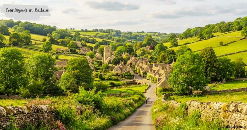 High-angle view of a quaint countryside in British with stone cottages and a church tower nestled in lush green rolling hills.