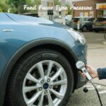 "Checking Ford Focus tyre pressure at a service station using an air hose gauge."
