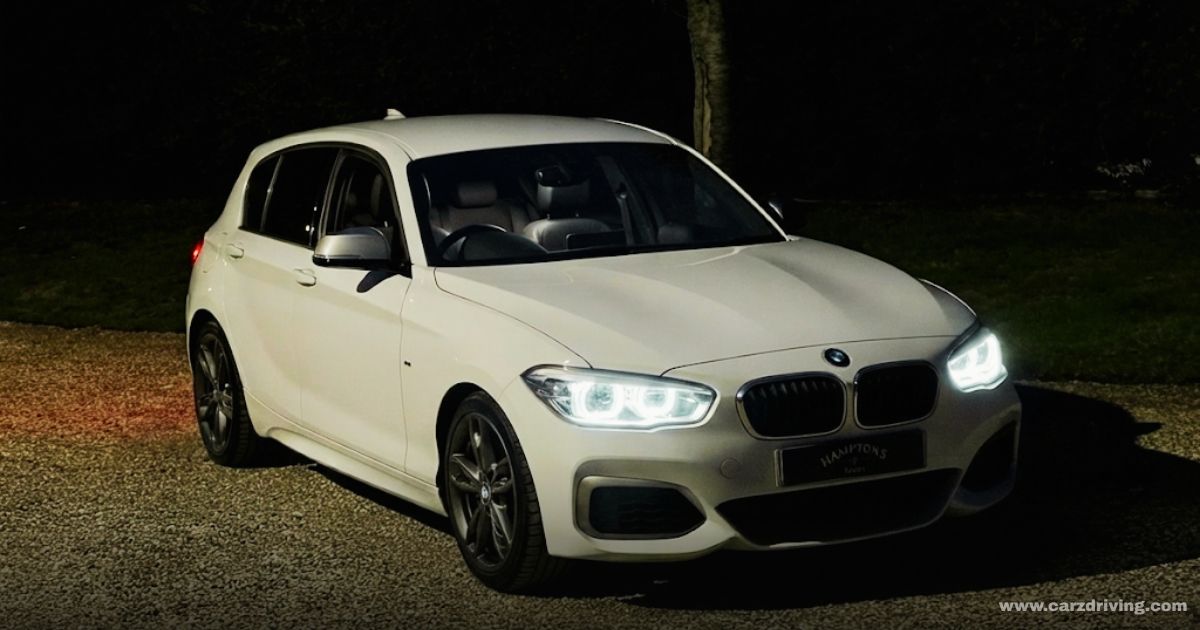 White BMW M140i hatchback parked at night
