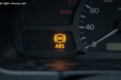Illuminated yellow anti lock brake system warning light on a car dashboard cluster.