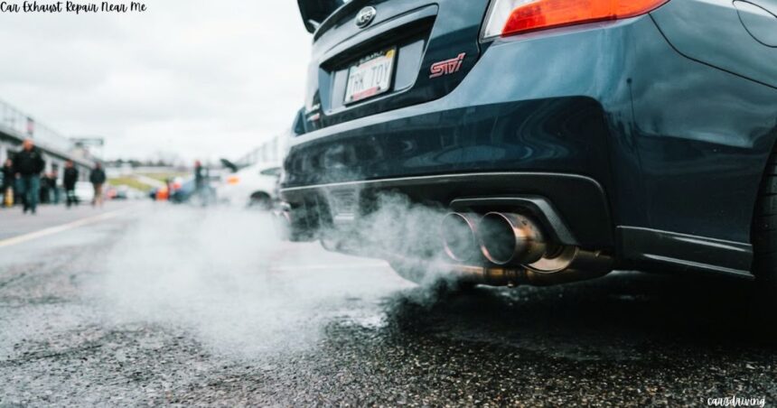 Rear view of a dark grey Subaru STI parked on wet pavement with exhaust smoke billowing from its dual exhaust pipes.