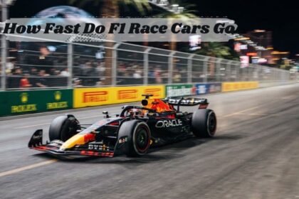 An F1 race car accelerating at high speed past barriers during a night grand prix event. at the mid lay how fast do f1 race cars go