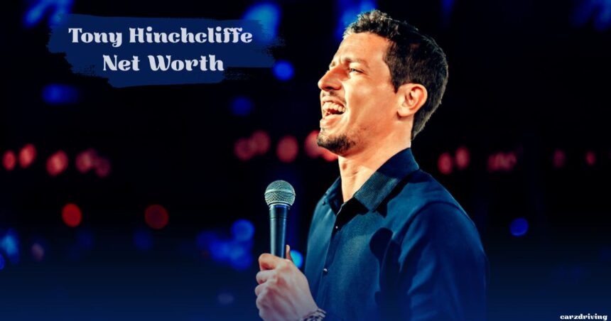 Comedian Tony Hinchcliffe smiling and holding a microphone on stage, with "Tony Hinchcliffe Net Worth" in bold white text overhead.