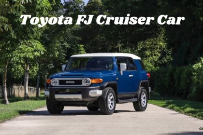 A blue and white Toyota FJ Cruiser car parked on a scenic, tree-lined paved road.
