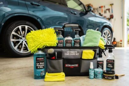 Complete car cleaning kit bag showing Detailmaster Pro car care products, spray bottles, applicator pads, and cleaning cloths set in front of a blue SUV.