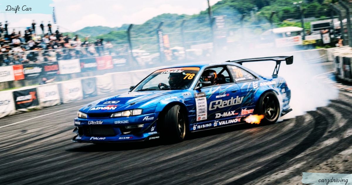 Blue Nissan Silvia S14 drift car sliding around a corner on a track, producing dense white tire smoke and a burst of flame from the exhaust, with spectators watching from the grandstands in the background.