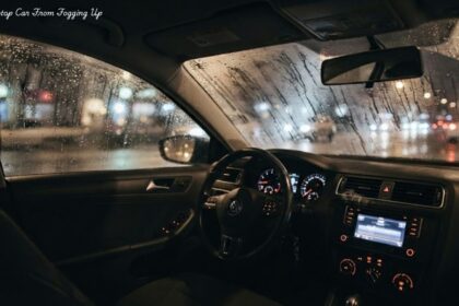 Fogged-up car windshield and rainy windows at night illustrating how to stop car windows from fogging up. and how to stop car from fogging up lay at the corner