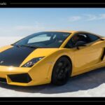 A yellow Lamborghini Gallardo Automatic sports car with a black hood driving across a vast open salt flat under a clear blue sky.