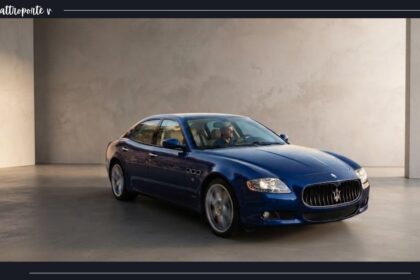 Blue Maserati Quattroporte V luxury sedan parked inside a modern studio showroom with neutral concrete textured walls and smooth flooring