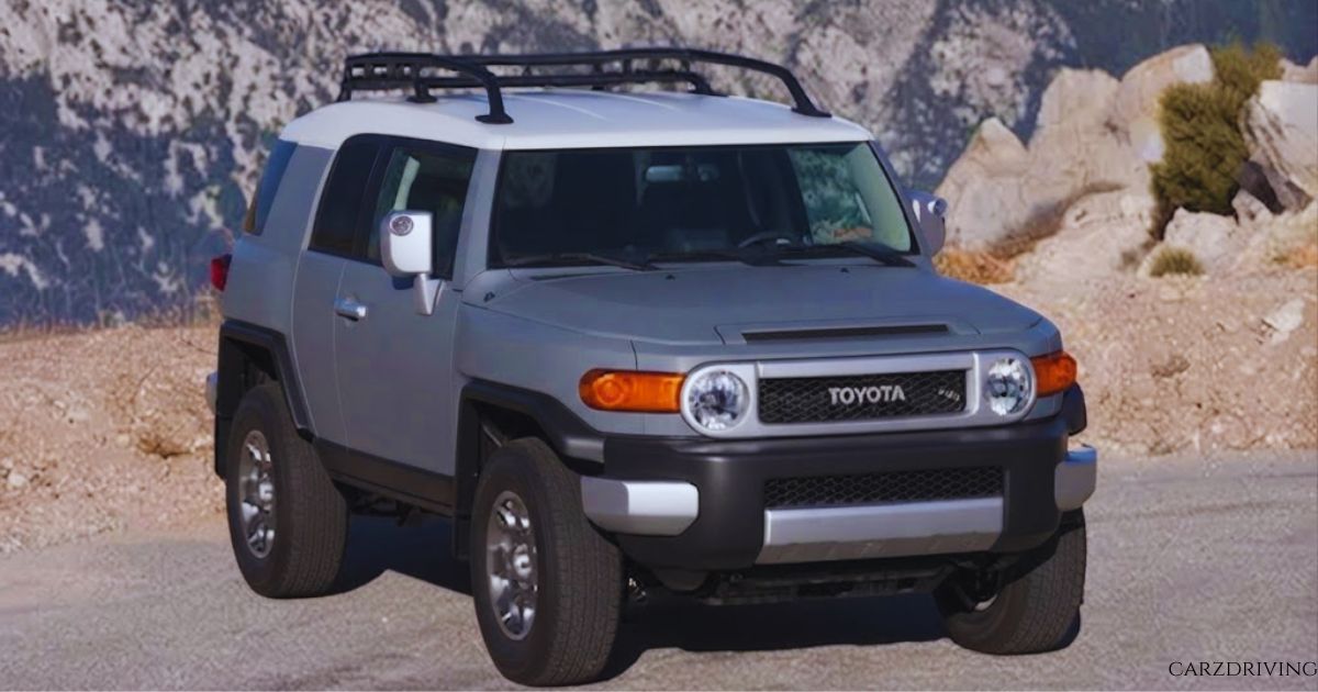 A gray and white Toyota FJ Cruiser car with a roof rack parked on a mountain trail.